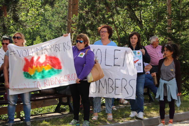 Imatge de tres manifestants a l'exterior del Parc de Bombers del Pont de Suert amb pancartes reivindicatives. Imatge del 29 de juny del 2017. (horitzontal)