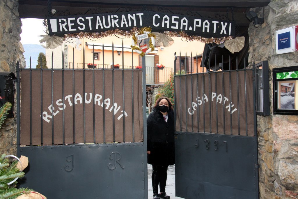 Pla sencer de la presidenta de l'Associació de bars i restaurants de la Cerdanya, Nativitat Bover, tancant la porta del seu restaurant, el 23 de desembre del 2020. (Horitzontal)