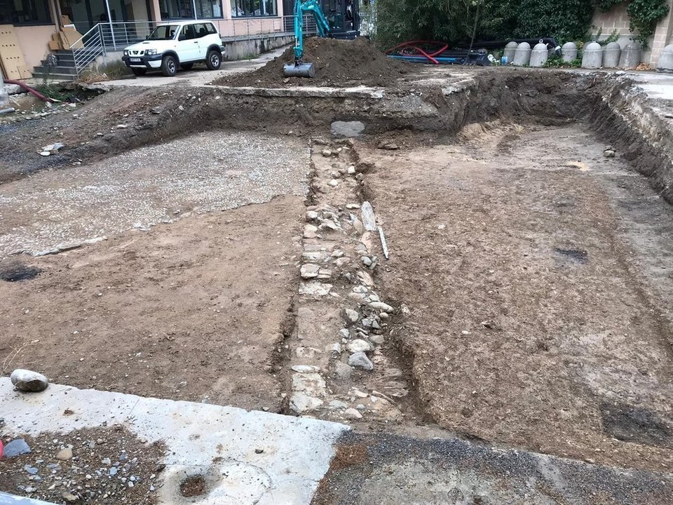 Pla obert on es veu el tram de la muralla baix medieval descobert al jaciment del pati de les Monges de la Seu d'Urgell durant les tasques de delimitació de la zona arqueològica. Imatge del 9 de setembre de 2021. (Horitzontal)