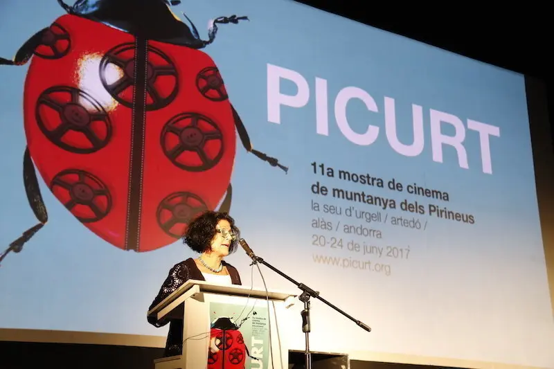 En primer pla de la imatge la directora del PICURT, Montse Guiu, al fons el cartell del festival d'enguany. Imatge del 20 de juny de 2017. (horitzontal)