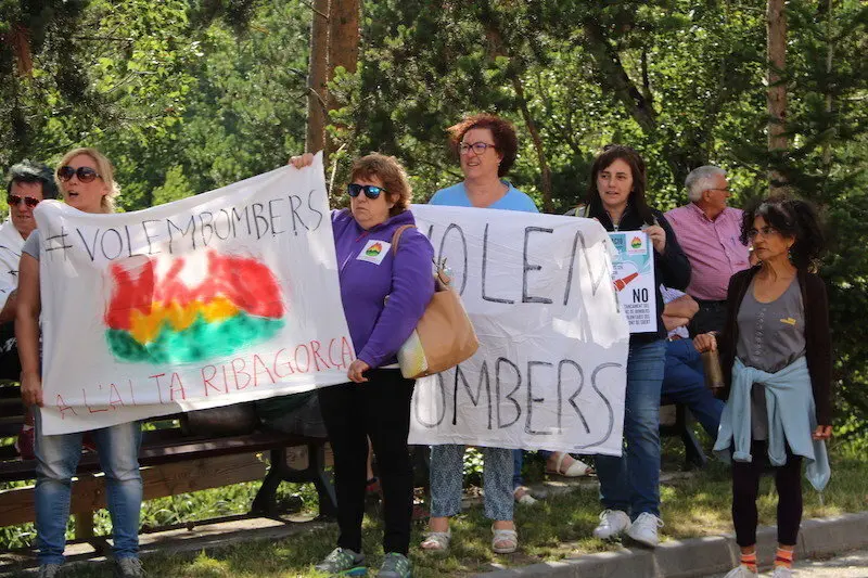 Imatge de tres manifestants a l'exterior del Parc de Bombers del Pont de Suert amb pancartes reivindicatives. Imatge del 29 de juny del 2017. (horitzontal)