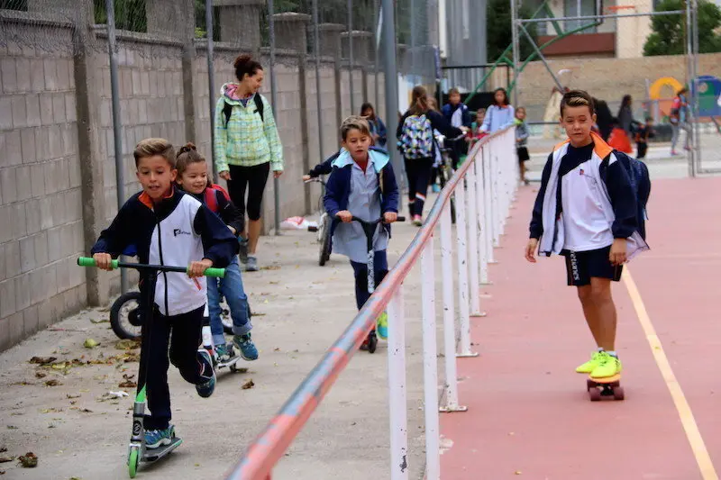 Un grup de nens i nenes arribant a l'escola amb bicicleta i patinet. Imatge del 18 de setembre del 2017. (horitzontal)