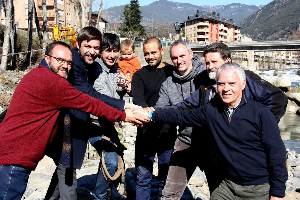 Pla mitj&radic;&dagger; de l'acalde de Sort, Raimon Monterde, i els portaveus d'Ipcena i Rius amb Vida, Joan V&radic;&deg;zquez i Josep Grau, a la llera del riu Noguera Pallaresa amb d'altres autoritats. Imatge del 14 de febrer de 2019 (Horitzontal).