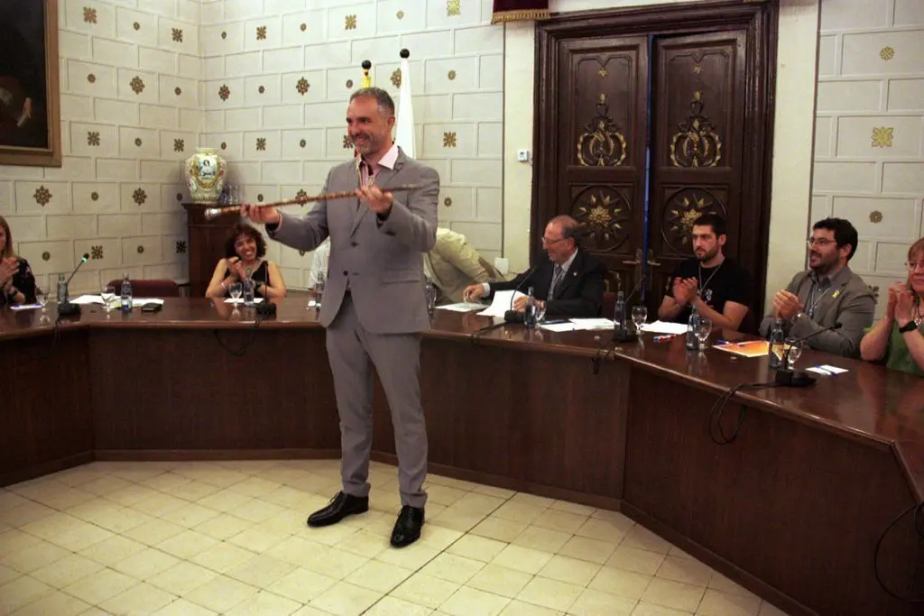 Pla general del nou alcalde de la Seu d'Urgell, Jordi F&radic;&dagger;brega, agafant la vara a la sala de plens del consistori on es veu, al darrere a la dreta, a Francesc Viaplana d'ERC, amb qui compartir&radic;&dagger; el c&radic;&dagger;rrec. Imatge del 15 de juny de 2019 (Horitzontal).