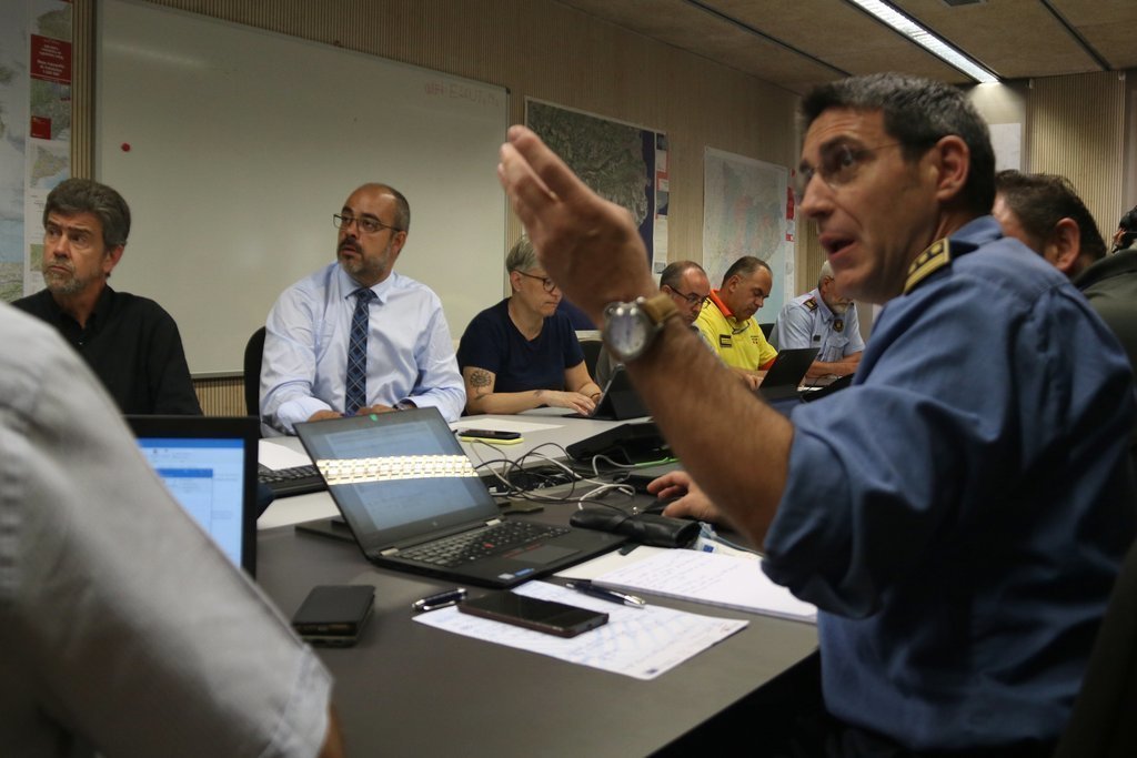 Jordi Bosch, responsable de la sala central de bombers, dona explicacions al conseller d'Interior, Miquel Buch, durant la reunió tècnca de lINFOCAT, l'1 de juliol de 2019. (horitzontal)