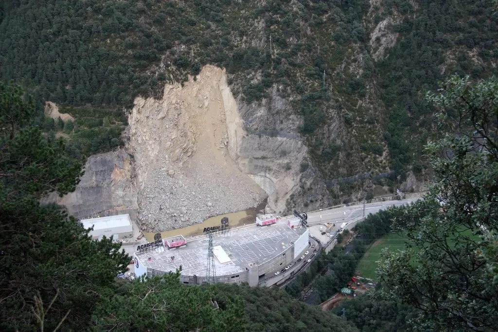 Pla general de l'esllavissada que s'ha produit a la carretera CG-1 d'Andorra vista des de la zona de la Borda Sabat&eacute; i on es veu un forat ple d'aigua i el sostre del centre comercial Punt de Trobada al davant, el 10 d'agost de 2019 (Horitzontal).