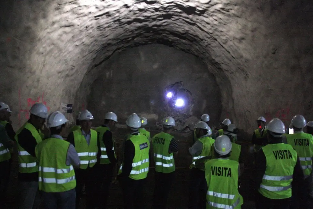 Pla general de les autoritats que han assistit a la calada del t&uacute;nel de Tresponts observant com els operaris fan un forat per unir les dos boques des de l'altre costat. Imatge del 30 d'agost de 2019 (Horitzontal).