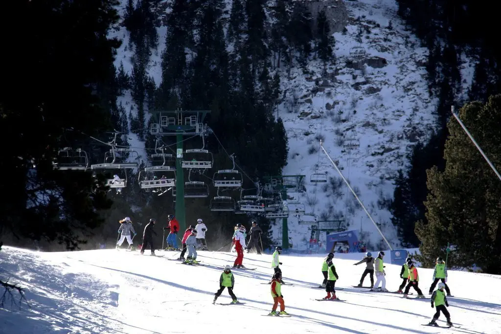 Pla general d'una de les pistes de l'estaci&oacute; de la Molina (Cerdanya) on es veuen desenes de persones baixant fins a la base i un dels remuntadors al darrera. Imatges del 25 de gener de 2019 (Horitzontal).