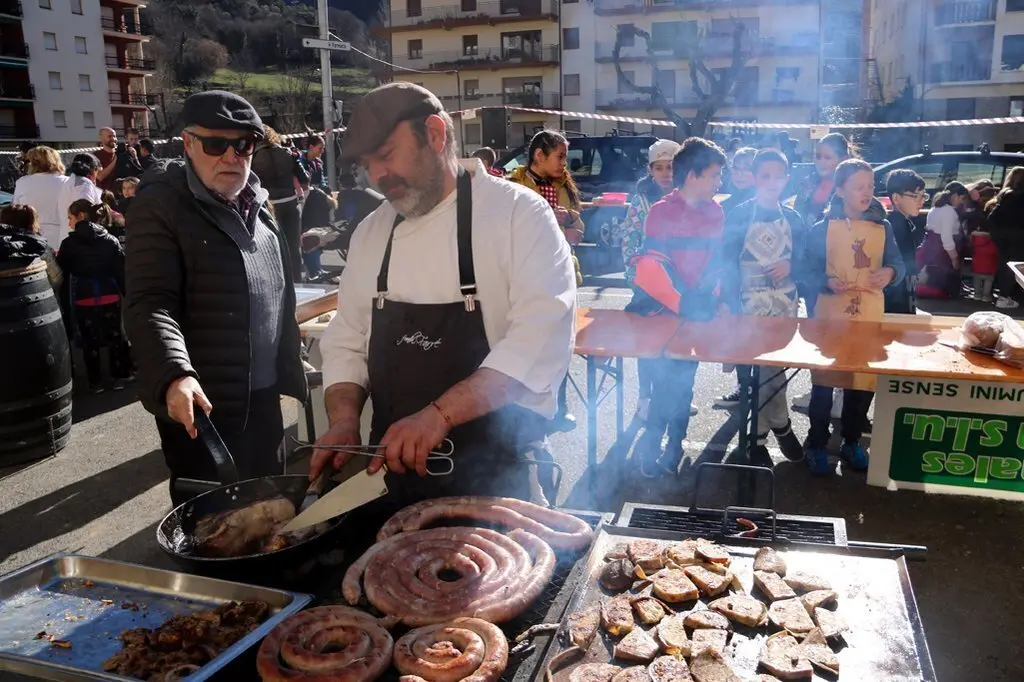 Un cuiner coent les llangonisses i el 'facit de carnaval' que han elaborat durant la Festa del Mandongo a Sort el 20 de febrer del 2020. (horitzontal)