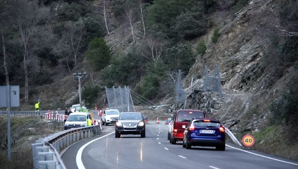 Pla general on es veuen cotxes aturats i d'altres circulant en pas alternatiu pel punt de la C-13 on aquest divendres es va produir una esllavissada que va obligar a tallar la carretera. Imatge del 29 de desembre de 2019 (Horitzontal).