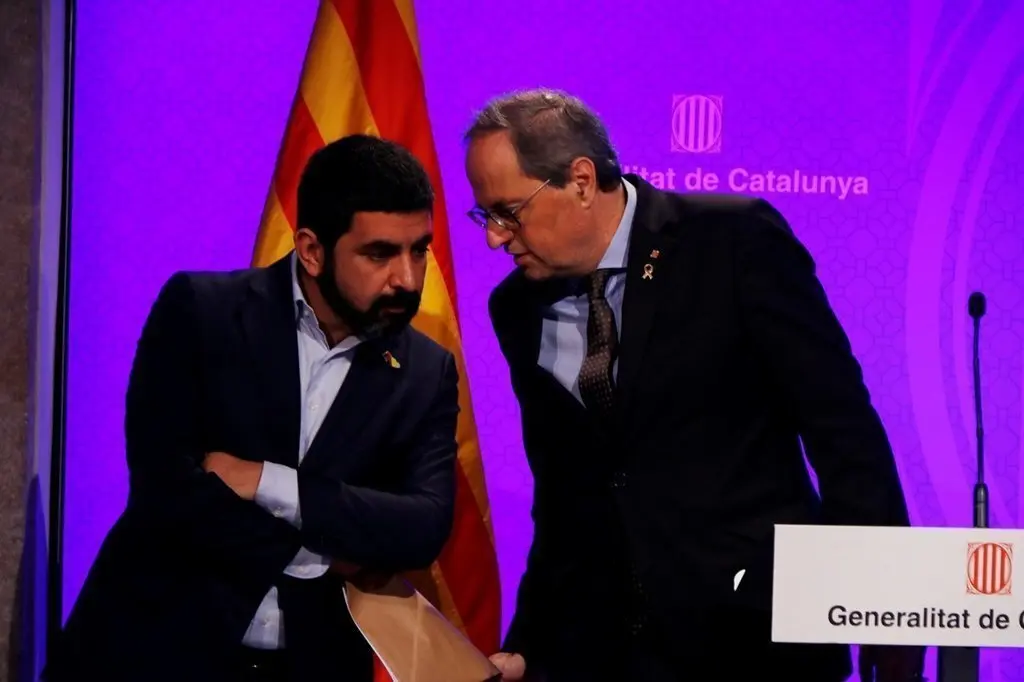 Pla mitj&agrave; del president del Govern, Quim Torra, parlant amb el conseller Chakir El Homrani durant la roda de premsa pel coronavirus. Imatge del 12 de mar&ccedil; del 2020. (Horitzontal)