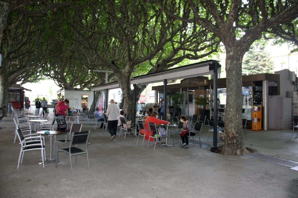 Pla general de la terrassa d'un quiosc-bar situat al passeig Joan Brudieu de la Seu d'Urgell, on es veu gent asseguda en algunes taules i la separació que hi ha entre elles. Imatge del 25 de maig de 2020 (Horitzontal).