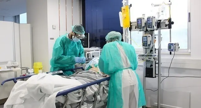 Pla mitj&agrave; de dos metges tenint cura d'un pacient amb coronavirus aquest dissabte 18 d'aril de 2020 a l'hospital Trueta. (Horitzontal)
