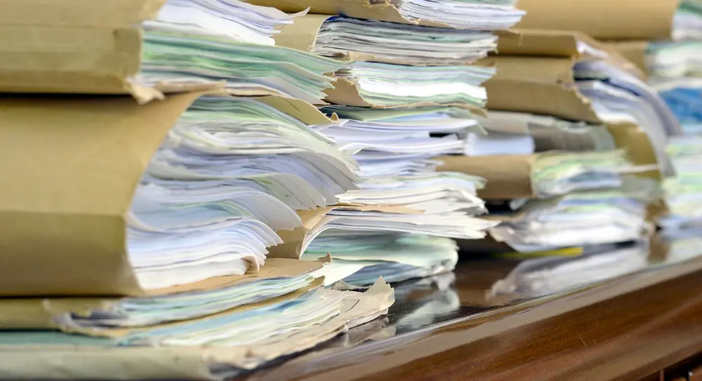 heap fo paper folders on wooden desk