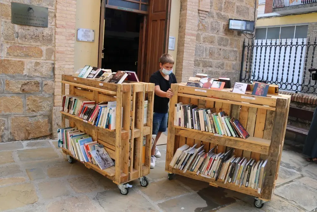 Un jove voluntari obrint la botiga del Jard&iacute; dels Llibres a la Pobla de Segur el 9 de juliol del 2020. (horitzontal)