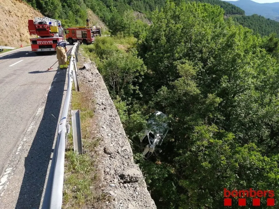 Imatge cedida pels Bombers d'una furgoneta penjada en uns arbres despr&eacute;s de caure per un barranc el 21 de juliol del 2020. Pla general. (Horitzontal)