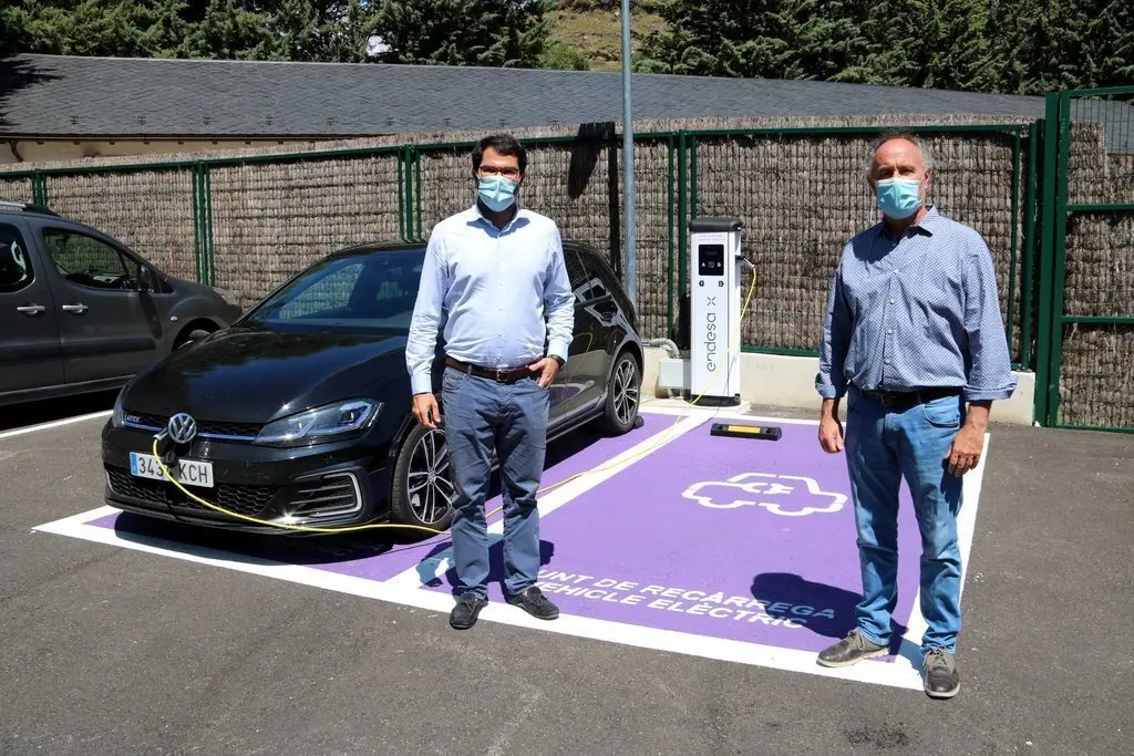Ferran Menescal, responsable de mobilitat el&egrave;ctrica d'Endesa X a Catalunya, i Josep Vidal, alcalde de Llavors&iacute;, davant els dos punts de rec&agrave;rrega de Llavors&iacute;. Imatge del 24 de juliol del 2020. (horitzontal)