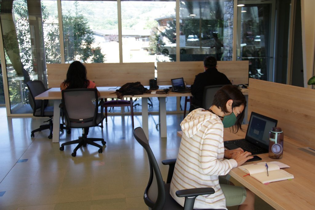 Pla obert de l'interior de l'espai de 'coworking' de Prullans (Cerdanya) on es veuen diverses persones treballant-hi. Imatge del 25 d'agost de 2020 (Horitzontal).