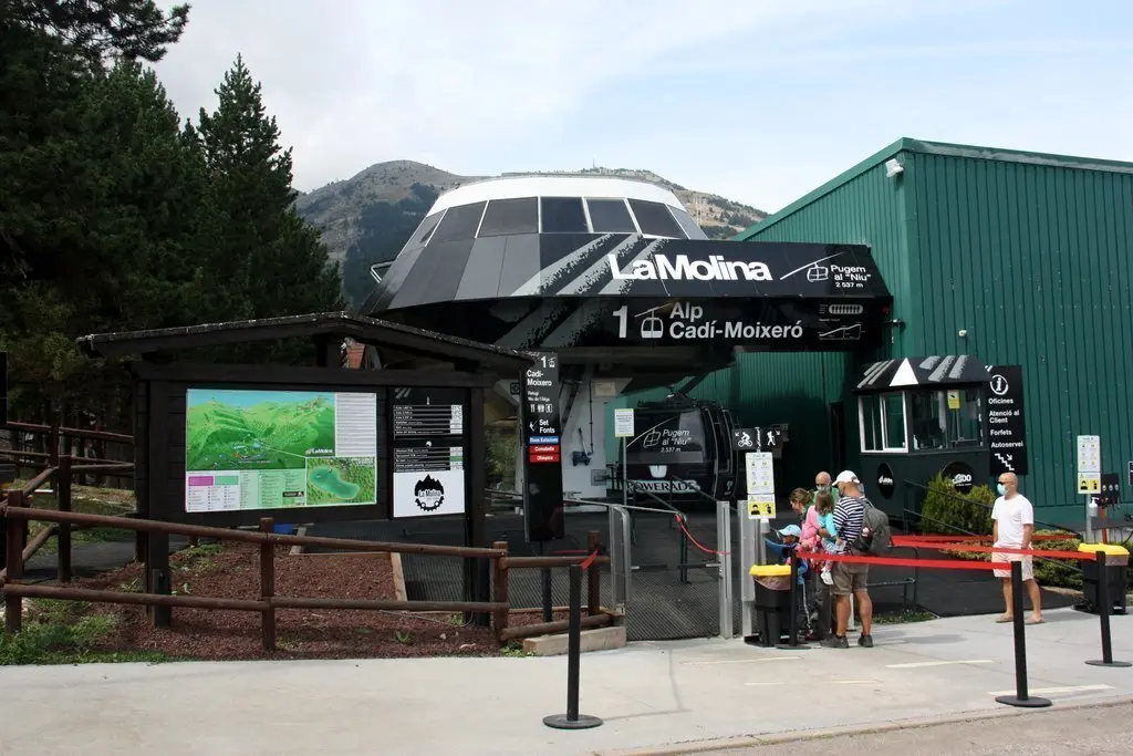 Pla obert on es veuen diverses persones a punt de pujar al telecabina de La Molina per anar fins al refugi del Niu de l'&Agrave;liga, a 2.537 metres d'altitud. Imatge del 28 d'agost de 2020 (Horitzontal).