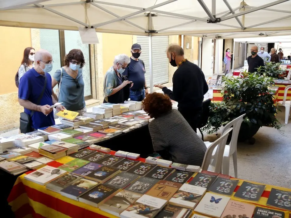 Pla general de diverses persones mirant llibres en una parada de la 24a Fira del Llibre del Pirineu a Organy&agrave;, el 5 de setembre de 2020. (Horitzontal)