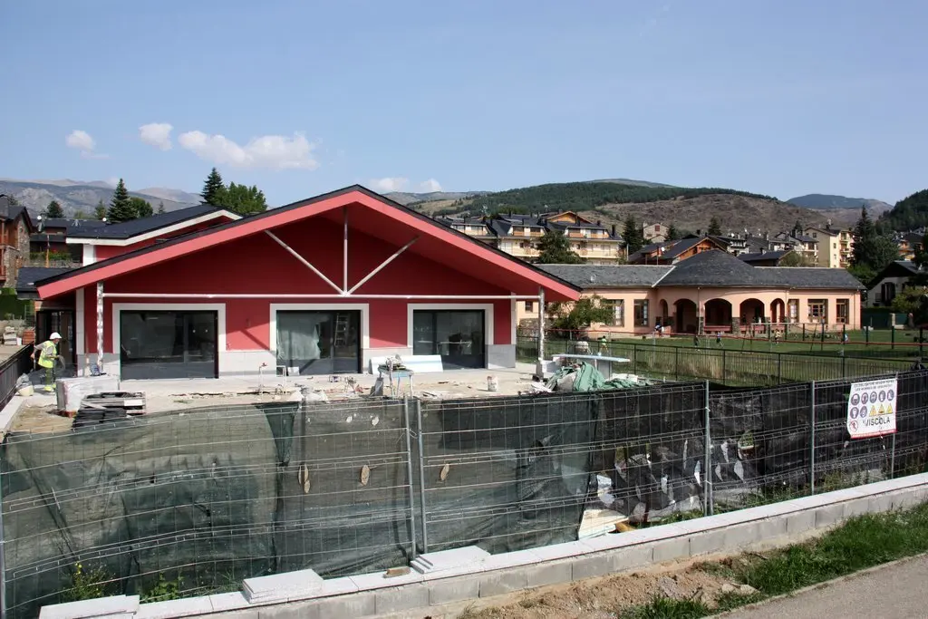 Pla general de les obres del nou edifici de l'escola de Ll&iacute;via (Cerdanya), en la seva recta final, i on es veu el pati i les actuals depend&egrave;ncies al fons. Imatge del 17 de setembre de 2020 (Horitzontal).