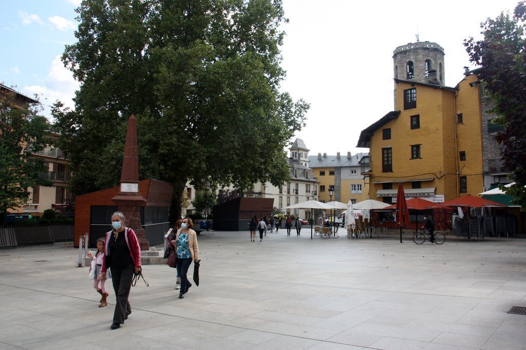 Pla general de persones passejant per la plaça de Santa Maria de Puigcerdà i on es veuen terrasses de bar amb les taules separades al fons. Imatge del 23 de setembre de 2020 (Horitzontal).