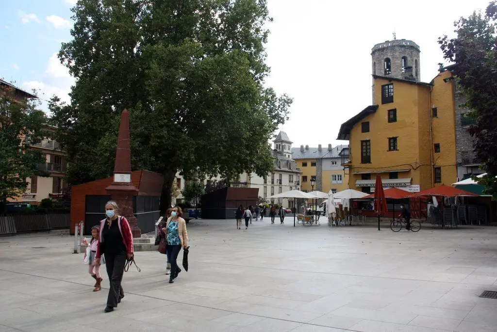 Pla general de persones passejant per la pla&ccedil;a de Santa Maria de Puigcerd&agrave; i on es veuen terrasses de bar amb les taules separades al fons. Imatge del 23 de setembre de 2020 (Horitzontal).
