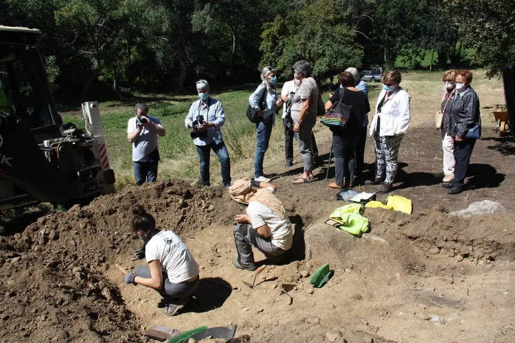 Pla obert de dos arque&ograve;legs treballant en l'excavaci&oacute; d'una fossa de la Guerra Civil a Sorpe, a l'Alt &Agrave;neu (Pallars Sobir&agrave;), i familiars de les v&iacute;ctimes que hi hauria enterrades mirant-ho al seu costat, el 2 de setembre de 2020 (Horitzontal).