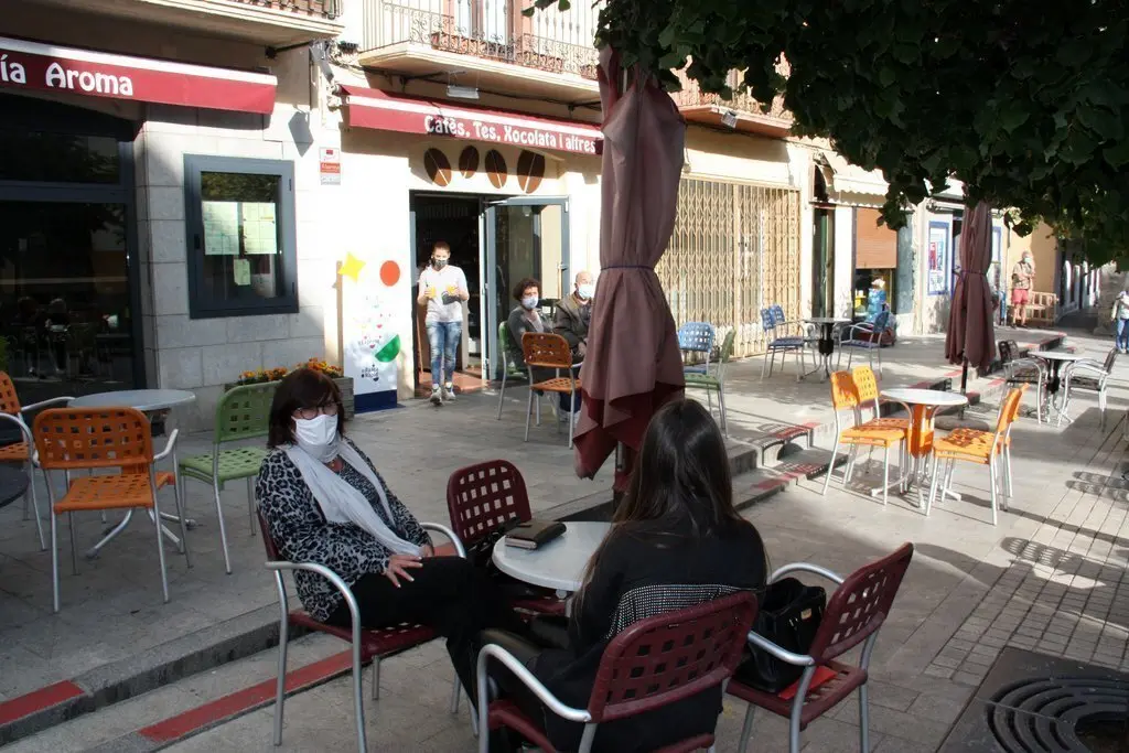 Pla general de diverses persones assegudes en una terrassa de bar del passeig Deu d'Abril de Puigcerd&agrave; on es veuen les taules separades. Imatge del 23 de setembre de 2020 (Horitzontal).