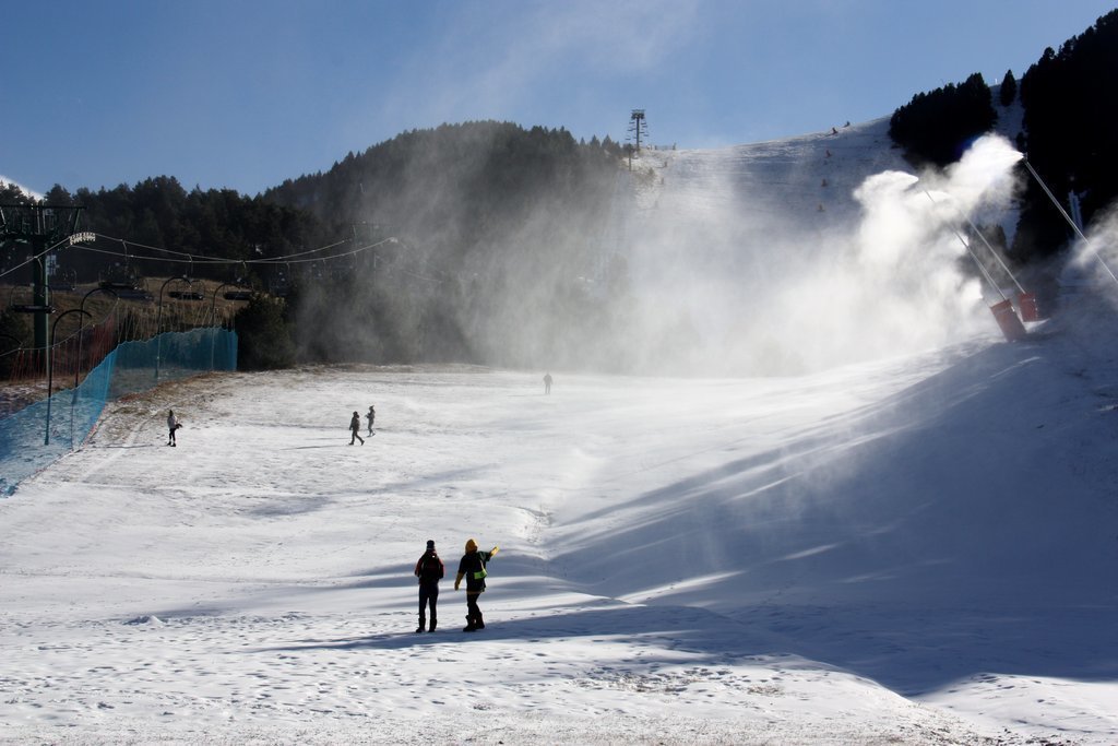 Pla obert on es veu una de les pistes d'esquí de La Molina (Cerdanya), amb els canons produint neu i algunes persones passejant-hi. Imatge del 2 de desembre de 2020 (Horitzontal).
