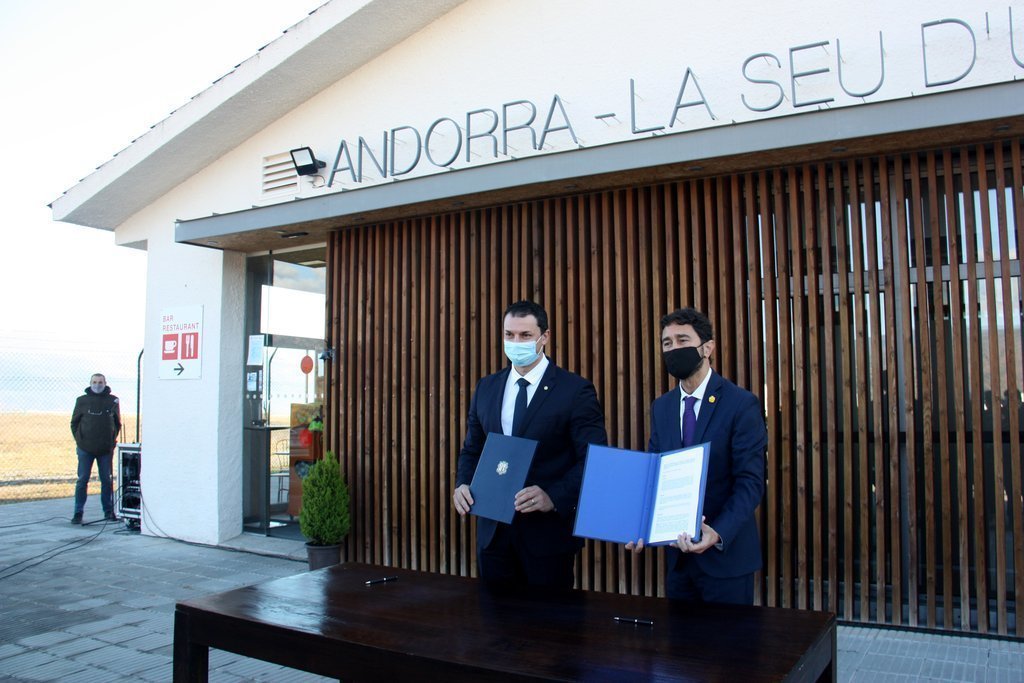 Pla americà del conseller de Territori, Damià Calvet, i el ministre de Presidència, Economia i Empresa d'Andorra, Jordi Gallardo, amb el conveni sobre la gestió de l'aeroport d'Andorra - La Seu que acaben de signar, el 18 de desembre de 2020 (Horitzontal)