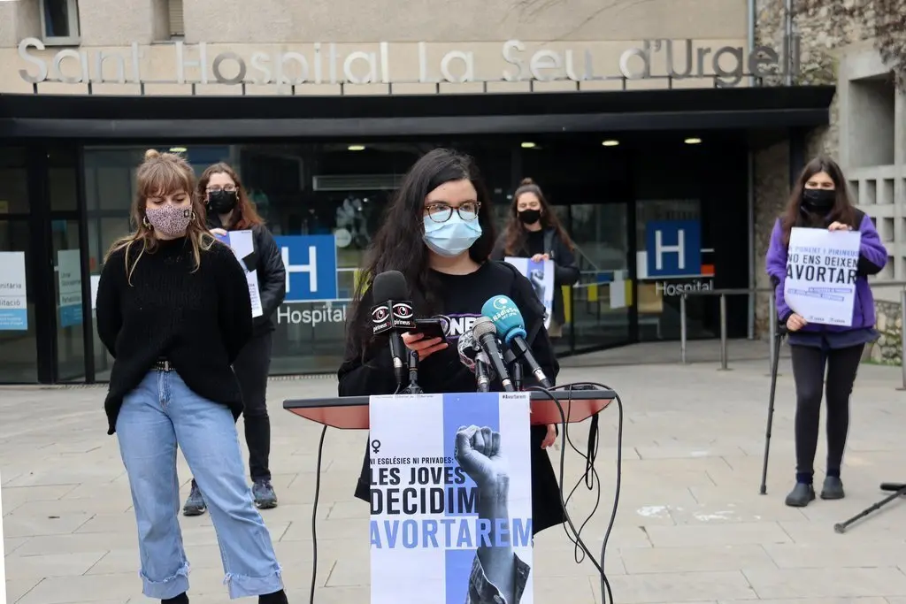 Pla americ&agrave; d'una militant d'Arran a Ponent, la Maria, presentant la campanya 'Les joves decidim, avortarem!' davant la Fundaci&oacute; Sant Hospital de la Seu d'Urgell on no es duu a terme aquesta pr&agrave;ctica. Imatge del 2 de mar&ccedil; de 2021 (Horitzontal).