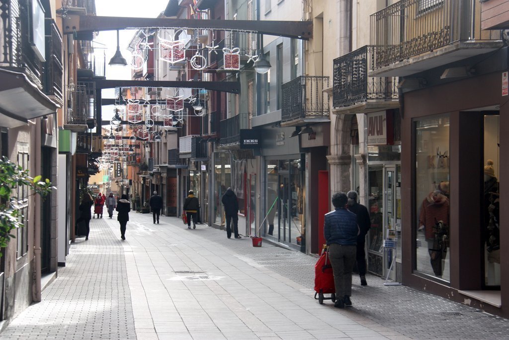 Pla obert on es veuen algunes persones passejant pel carrer Major de Puigcerdà, amb menys afluència de gent pel confinament perimetral de la Cerdanya. Imatge del 29 de desembre de 2020 (Horitzontal).