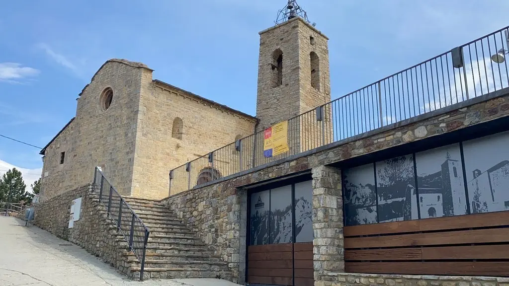 Pla obert on es veu l'entrada del Centre d'Interpretaci&oacute; del pa&iacute;s dels Esterregalls i l'esgl&eacute;sia de Santa Maria d'All, a Is&ograve;vol (Cerdanya). Imatge del 8 d'abril de 2021 (Horitzontal).