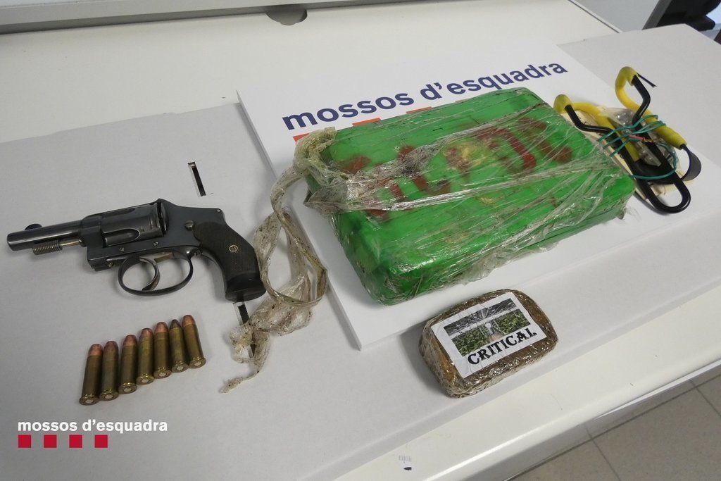 Pla mitjà on es pot veure l'arma i altres elements intervinguts pels Mossos d'Esquadra al pis de la parella detinguda a Puigcerdà per tràfic de drogues, el 29 d'abril de 2021. (Horitzontal)
