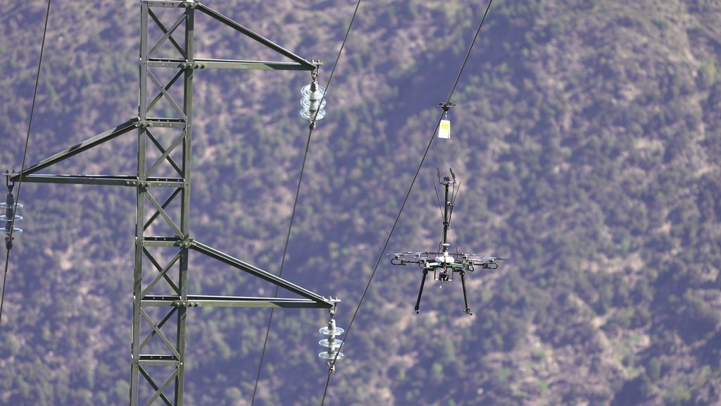 Pla de detall d'un dron col·locant senyalització a una línia elèctrica per evitar l'impacte de les aus al municipi de Rialp el 17 de maig del 2021 (horitzontal)