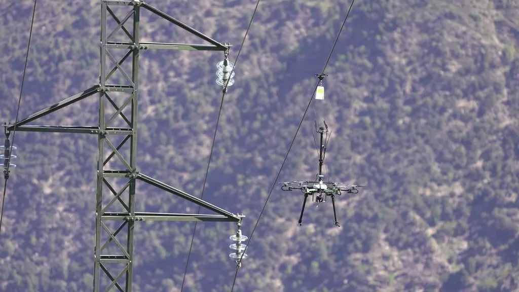 Pla de detall d'un dron col&middot;locant senyalitzaci&oacute; a una l&iacute;nia el&egrave;ctrica per evitar l'impacte de les aus al municipi de Rialp el 17 de maig del 2021 (horitzontal)