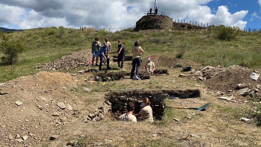 Pla general de l'equip d'arqueòlegs treballant als sondejos que han fet a l'entorn del castell de Llívia, amb el director de les excavacions de 'Iulia Libica', Cèsar Carreras, explicant la tasca duta a terme. Imatge del 15 de juliol de 2021. (Horitzontal)