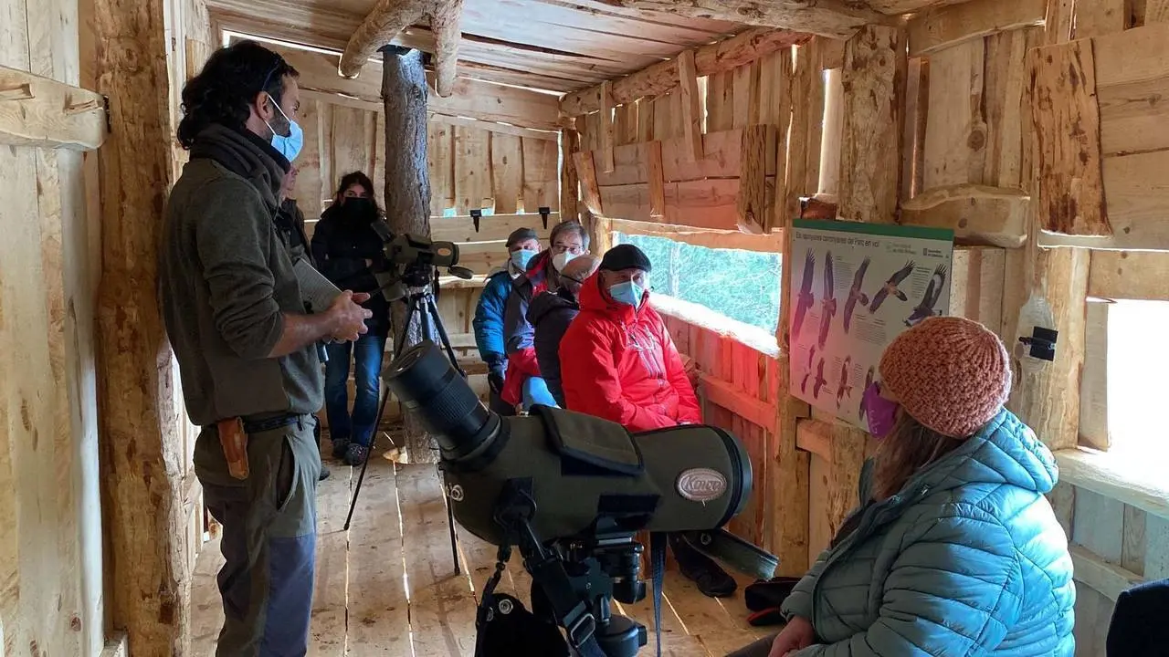 Pla mitj&radic;&dagger; on es veuen diverses persones a l'interior del punt d'aguait d'aus carronyaires situat a l'Obaga d'Orteu d'Embonui, al municipi de Soriguera (Pallars Sobir&radic;&dagger;). Imatge del 7 de desembre de 2021. (Horitzontal)