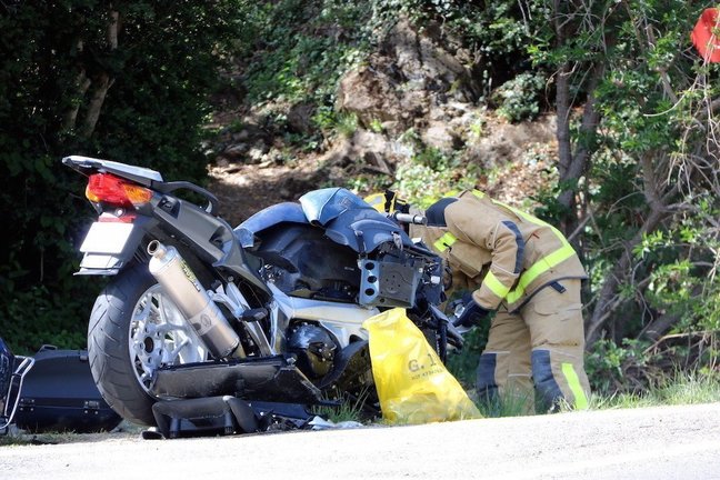 Un bomber recollint les restes de la moto accidentada. Imatge del 18 d'abril del 2017. (horitzontal)