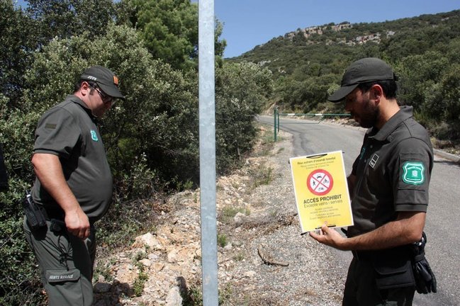 Pla americ√† de dos efectius dels Agents Rurals a punt de col¬∑locar un cartell que indica que est√† prohibit accedir a la serra del Montsec, el 27 de juny de 2019 (Horitzontal).