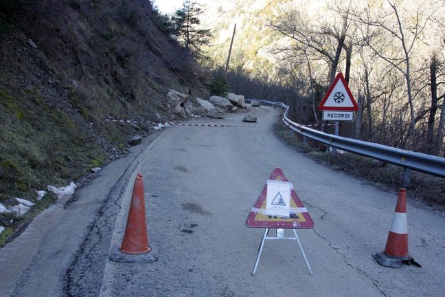 Pla general d'un senyal de carretera tallada al punt on han caigut diverses roques a la calçada, a la carretera local que va des de l'N-145 a diversos nuclis del municipi de les Valls de Valira (Alt Urgell). Imatge del 5 de febrer de 2020 (Horitzontal).