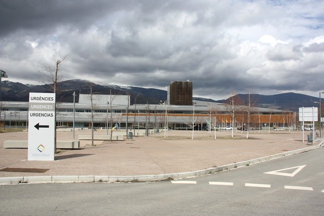 Pla general de l'exterior de l'edifici de l'Hospital de Cerdanya, on es veu en primer terme un cartell que indica on està la zona d'Urgències. Imatge del 13 de març de 2020 (Horitzontal).