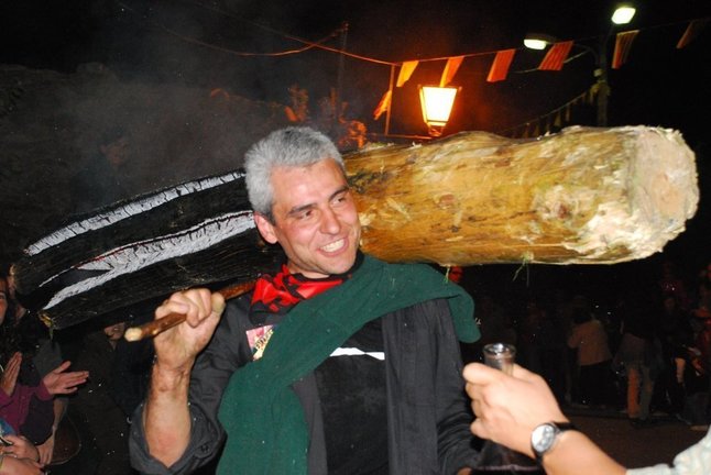 Un fallaire durant la celebració de les falles al poble d'Isil, al Pallars Sobirà. El fallaire porta a l'esquena una gran falla  encesa. (horitzontal)