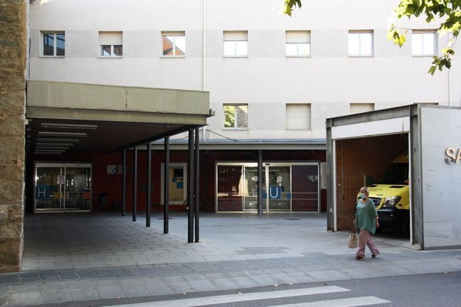 Pla obert on es veu una de les entrades del Sant Hospital de la Seu d'Urgell i una persona passant pel davant amb mascareta, el 20 d'agost de 2020 (Horitzontal).