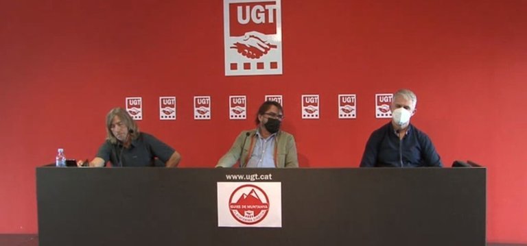 Pla obert del secretari general de la UGT de Catalunya, Camil Ros, amb el secretari general de la Plataforma Sindical dels Guies de Muntanya, Nando Gel, (esquerra), després de signar el conveni que permet crear l'ens, el 13 d'octubre de 2021 (Horitzontal)