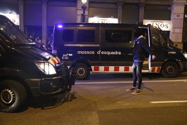 Un manifestant es planta davant de furgonetes dels Mossos d'Esquadra durant unes protestes contra l'empresonament del cantant Pablo Hasel el 17 de febrer del 2021 a Barcelona. Pla general. (Horitzontal)