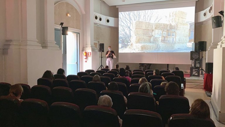 Pla obert on es veu una persona de l'organització del Cerdanya Film Festival presentant una de les projeccions del certamen al Museu Cerdà de Puigcerdà. Imatge del 10 d'agost de 2021 (Horitzontal).