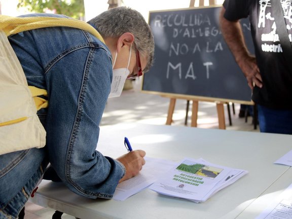 Pla tancat d'una dona signant al¬∑legacions contr√†ries al projecte de la MAT d'Osca al Pallars a Tremp, el 9 d'octubre de 2021. (Horitzontal)