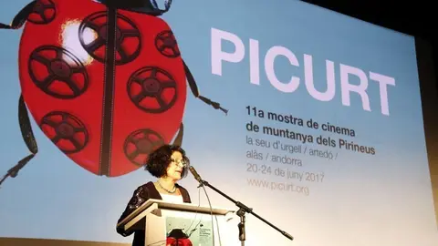 En primer pla de la imatge la directora del PICURT, Montse Guiu, al fons el cartell del festival d'enguany. Imatge del 20 de juny de 2017. (horitzontal)